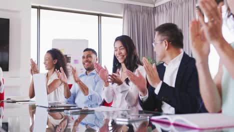 professional businesspeople clapping together in meeting room in modern office in slow motion