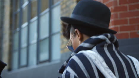 rear view of stylish fashion blogger walking on urban street