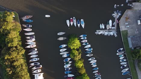 aerial top down shot of sailing boat arriving yacht club at sunset in buenos aires