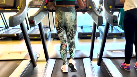 Soothing music accompanies fit woman&#039;s invigorating gym treadmill routine