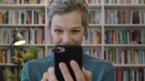 retrato de una mujer caucásica madura y amigable bibliotecaria enviando mensajes de texto navegando usando una aplicación de redes sociales de teléfono inteligente leyendo mensajes de texto expresión de sorpresa
