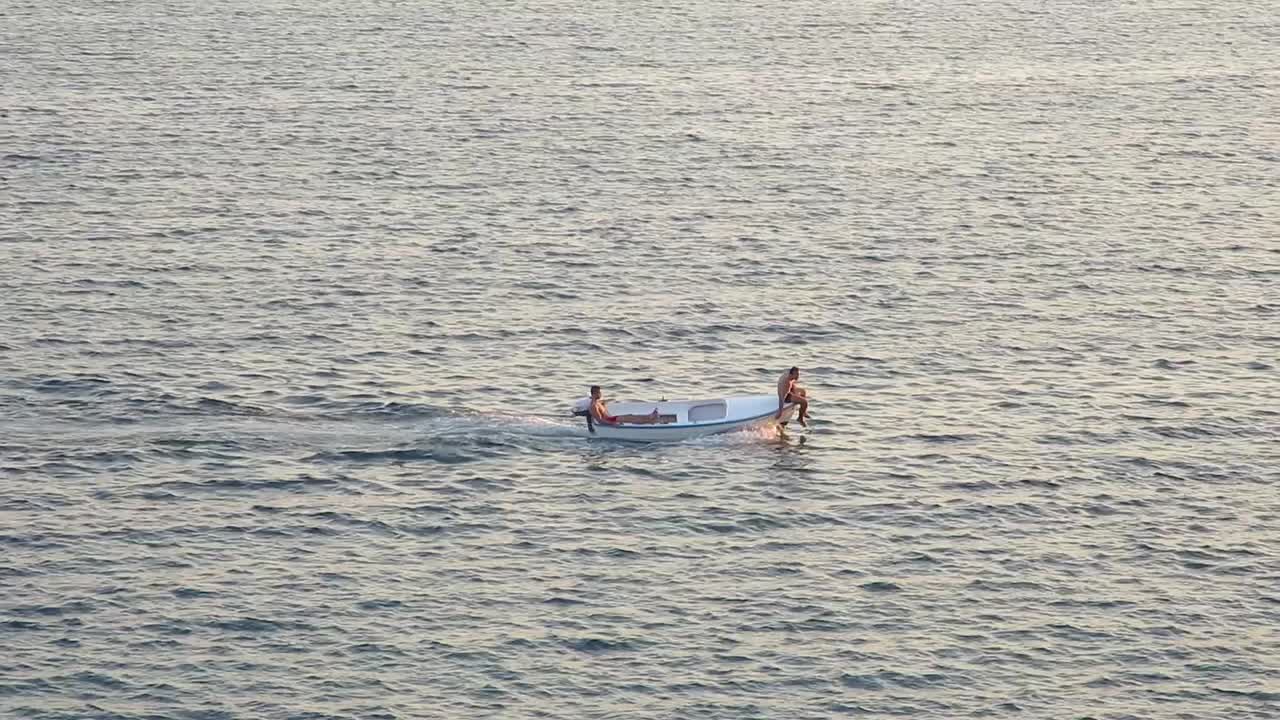 배 앞 에 앉아 있는 남자 들 과 함께 바다 를 지나가는 배