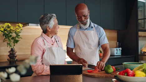 senior couple cooking together in the kitchen following an online recipe