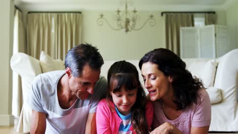 Parents-and-daughter-using-digital-tablet-in-living-room