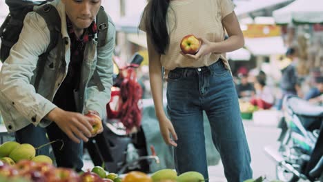 handheld view of vietnamese couple buying fruit at the market