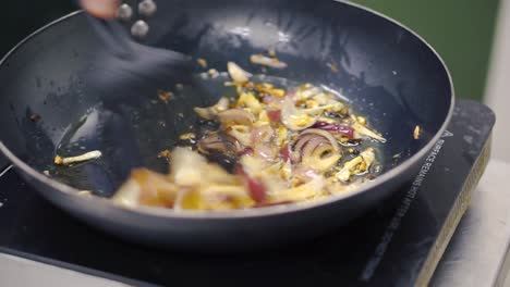 frying onions and garlic in a pan