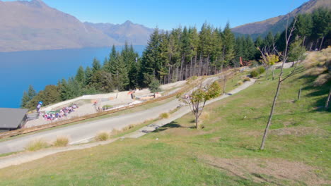 Gente-Montando-Paseos-En-Trineo-En-Queenstown-Con-El-Lago-Wakatipu-Al-Fondo