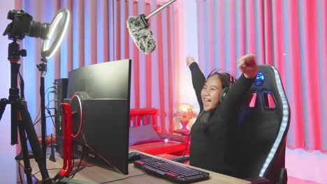 excited young girl making winner gesture while playing video game
