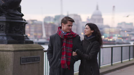 couple walking along south bank on winter visit to london