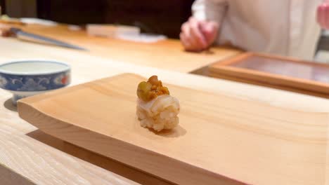 chef places sushi on wooden board