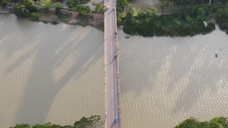 topdown view follow vehicles driving along bridge road over muddy river, bangladesh