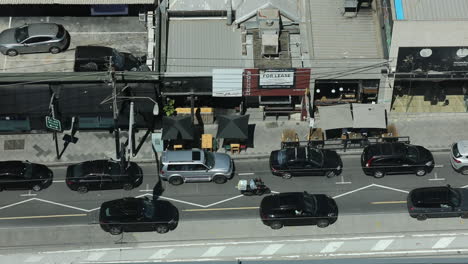 luxury cars driving along inner city urban street environment