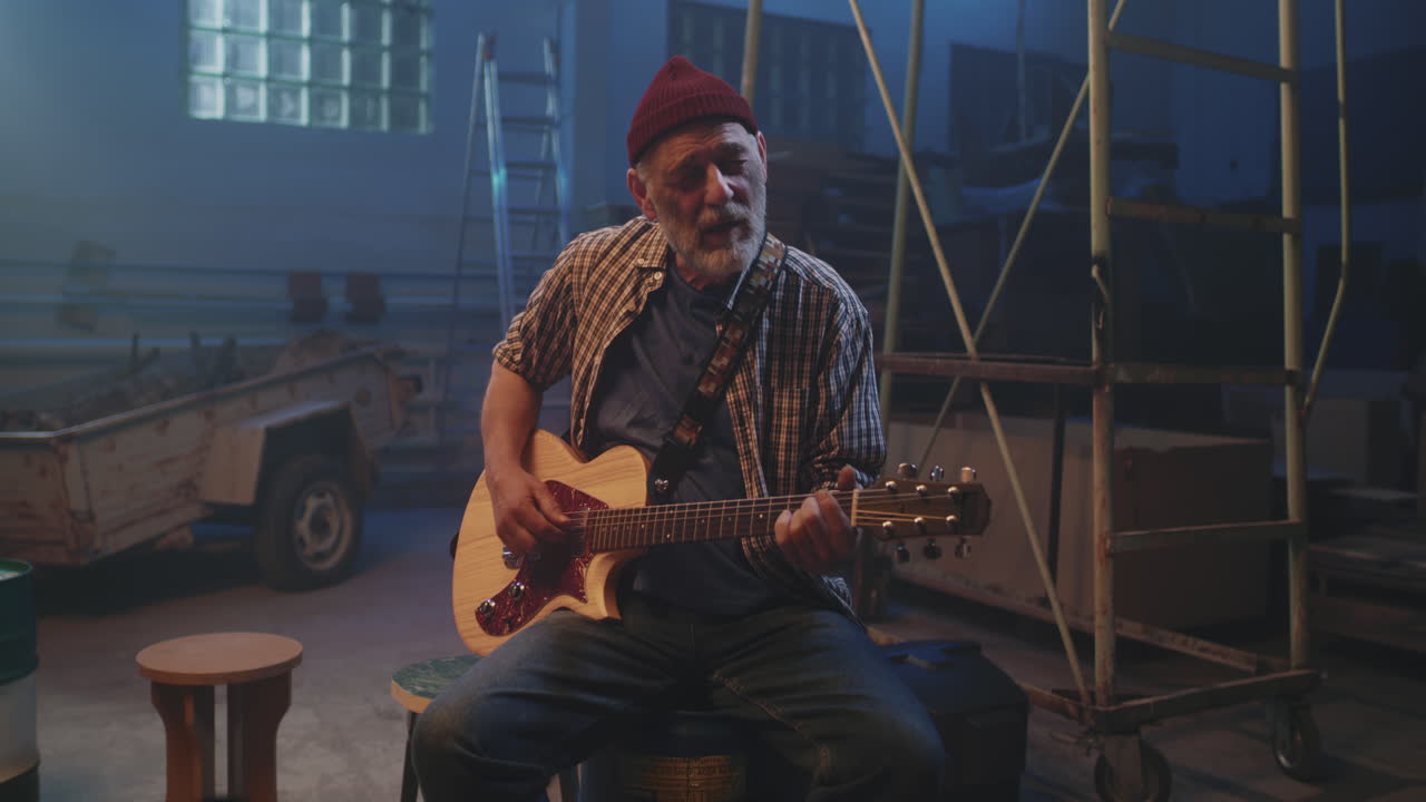 Elderly Man Playing Guitar in an Abandoned Warehouse