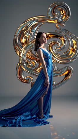 woman in a flowing blue gown with metallic abstract sculpture