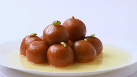 gulab jamun revolving with pistachio topping ( indian sweet ) | dessert