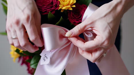 close up of flower arrangement with pink ribbon