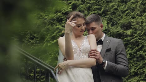 Newlyweds,-caucasian-groom-with-bride-stay-on-stairs-in-park,-wedding-couple,-man-and-woman-in-love