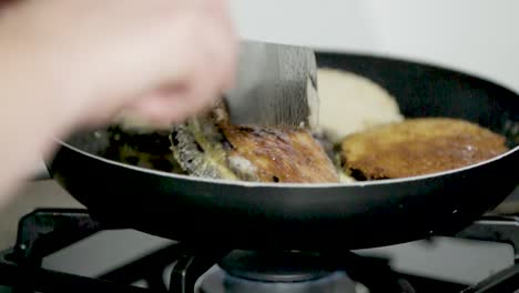 toma en cámara lenta a 400 fps de una hamburguesa de berenjena rellena de queso cubierta con pan rallado filmada en una cocina limpia y ordenada de clase media.