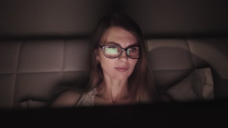 Woman working late on laptop in bed