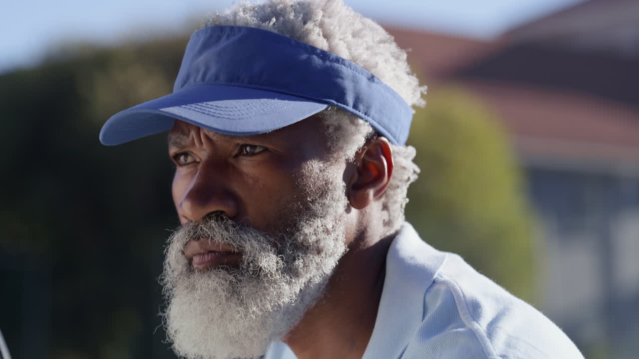 Older man with visor playing tennis