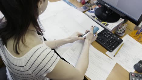 woman reviewing blueprints in office