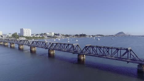 Flying-past-historic-Railway-bridge-Matapihi-in-New-Zealand,-aerial