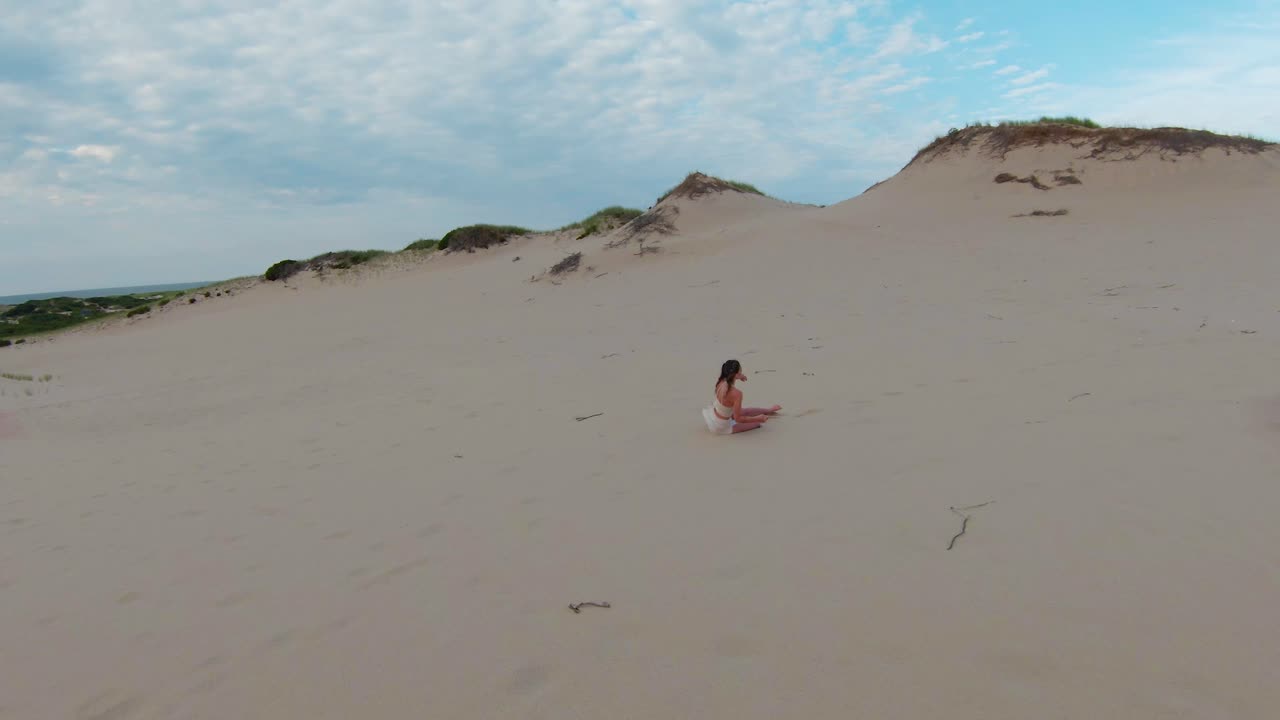 una vista de pájaro del paisaje desértico y siguiendo a una niña corriendo en las altas dunas de arena y senderos en el sendero de las cabañas de dunas en provincia, cape cod, massachusetts