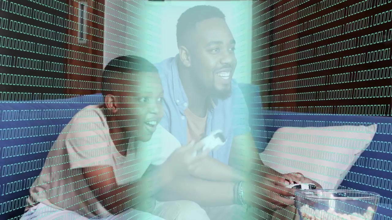 Dad pressing controller, son reaching, gaming for fun, binary overlay sweeping faces, pillow flying