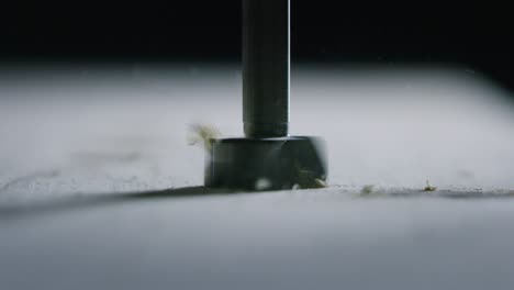 macro close up of professional carpenter working wood with drill machine in a workshop of wood factory.