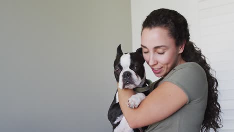 feliz mujer caucásica está jugando con su perro en casa