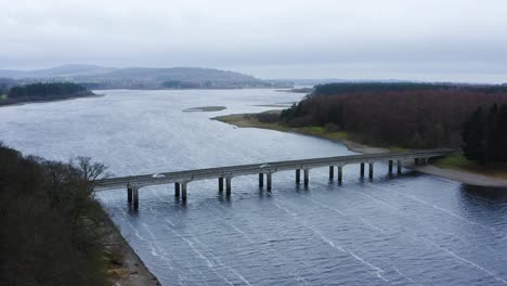 bridging horizons: aerial journey to baltyboys bridge over the river liffey in the wicklow mountains, amidst a cloudy evening drive
