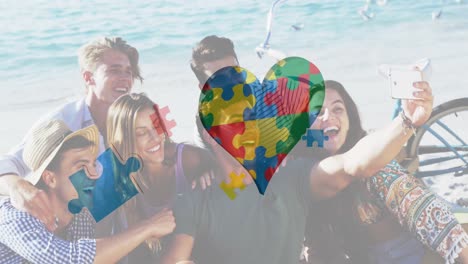 Animation of colourful puzzle pieces heart and autism text over happy friends at summer beach party