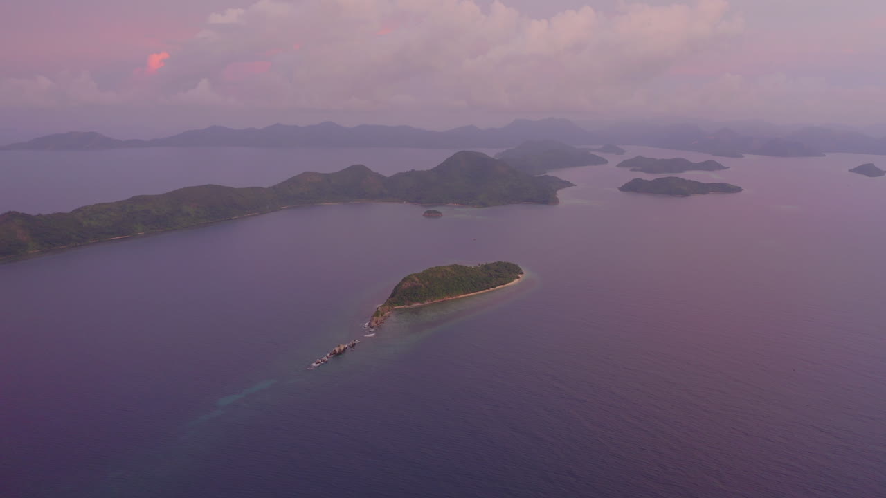 Matahari terbenam ungu dari drone di atas pulau-pulau tropis di Filipina saat golden hour