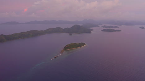 puesta de sol púrpura desde un dron sobre islas tropicales en filipinas a la hora dorada