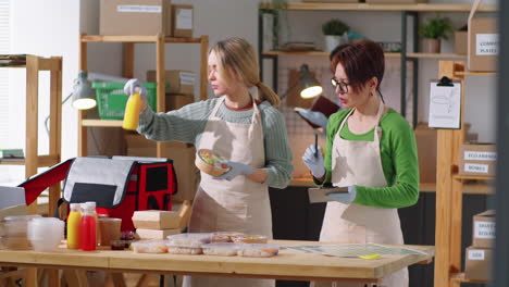 female colleagues preparing takeaway food for delivery