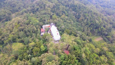 chicken church surrounded by forest landscape in indonesia, aerial orbit view