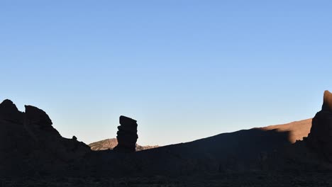 A-timelapse-captures-dawn's-early-light-gradually-illuminating-Roque-Cinchado-and-Roques-Garcia-in-Teide-National-Park,-Tenerife