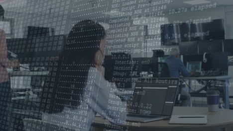 animation of computer code overlaying people working at office desks with laptops