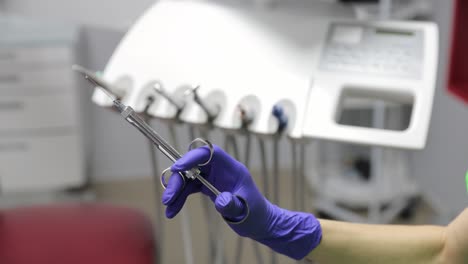 a dental professional is holding a specific instrument, preparing for an important procedure in a clinical setting.