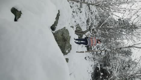 vertical shot of snow-covered mountain trails of mount chauve with female hiker in orford, quebec canada