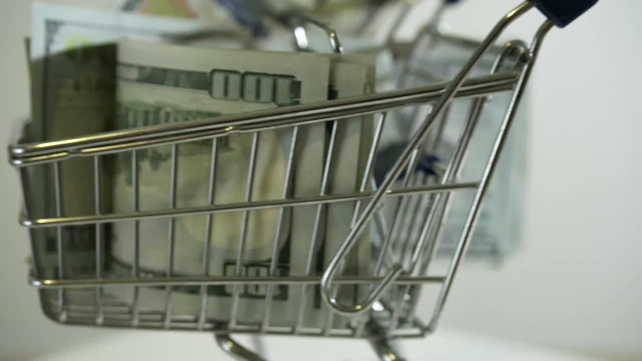 gráfico de compras con billetes de 100 dólares en fondo blanco