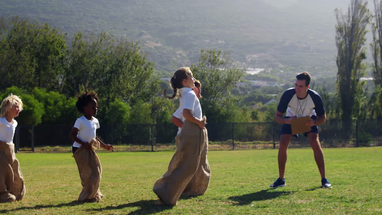공원 에서 가방 경주 를 하는 어린이 들