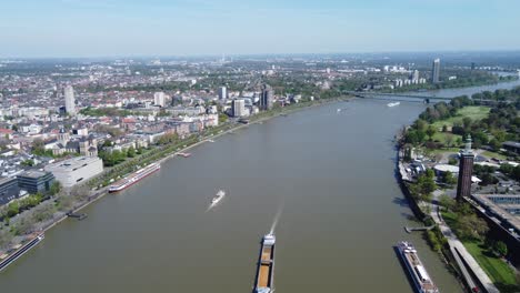 Flusslandschaft-Der-Stadt-Köln-Aus-Der-Luft,-Verschiedene-Arten-Von-Wasserstraßenschiffen,-Booten-Und-Tankschiffen,-Die-Den-Rhein-Befahren