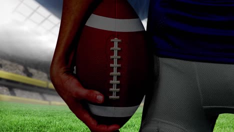 Animation-of-midsection-of-american-football-player-holding-ball-over-sports-stadium