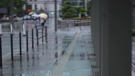 walking people on the street in marunouchi tokyo rainy day