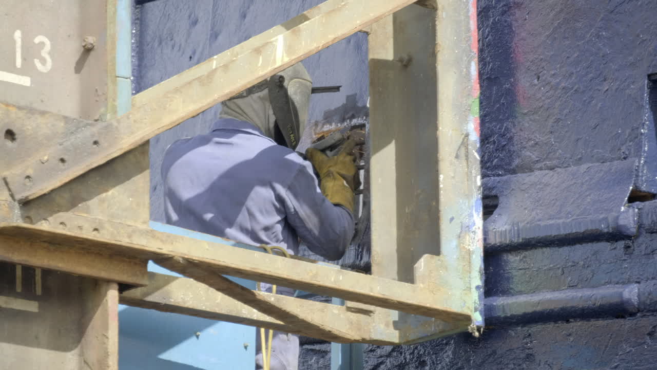 스코틀랜드 애버딘셔 프레이저버그 항구의 드라이 도크에서 대형 어선을 수리하는 도크 노동자