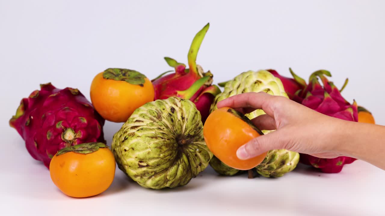 Mano seleccionando fruta de un arreglo colorido