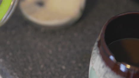 sugar being added and stirred into a hot cup of fresh coffee