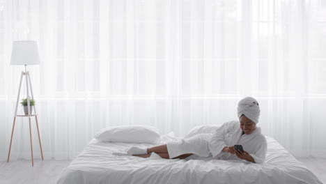 woman relaxing in bed with smartphone