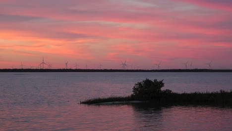 puesta de sol de lapso de tiempo en la bahía de nueces con vistas a un parque eólico